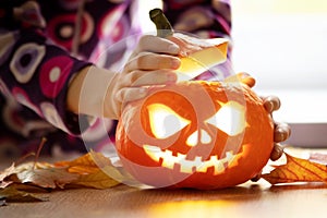 Child prepares a festive halloween pumpkin