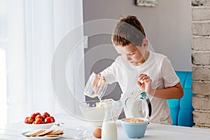 Child preparing cake and adding egg white to dough.
