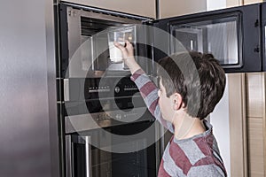 Child preparing a glass of milk