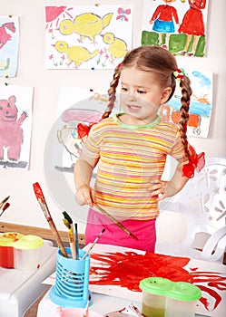 Child preschooler in orange draw picture.