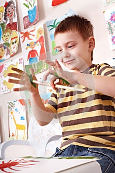 Child preschooler painting in classroom. photo