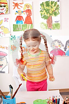 Child preschooler painting in classroom.