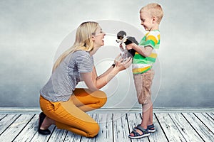 The child present his mother a small puppy.