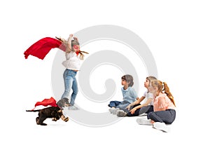 Child pretending to be a superhero with her super dog and friends sitting around