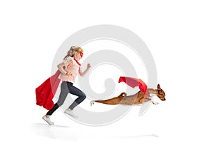 Child pretending to be a superhero with her super dog isolated on white studio background