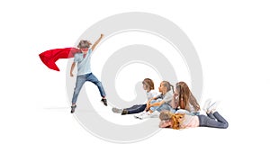 Child pretending to be a superhero with his friends sitting around