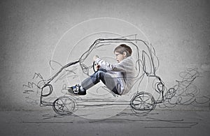 Child pretending to drive a drawn car photo