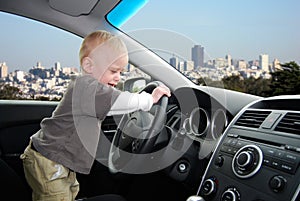 Child Pretends to Drive Car in Big City