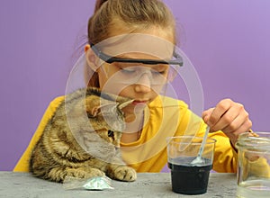 Child with protective eyeglasses makes science experiment at home with water and crystals