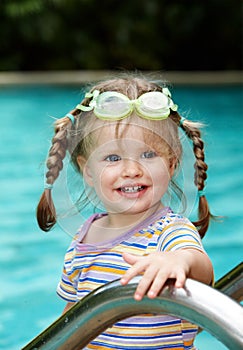 Child in protective goggles leaves pool.