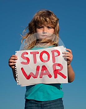 Child protest against war. Kid calls to Stop war, raises banner with inscription stop the war. Kids with poster with