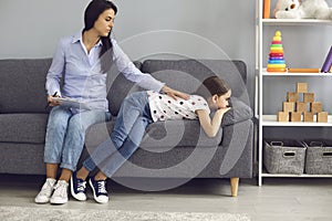 Child psychologist psychology. Woman psychologist with a clipboard helps a child with a problem in the room.