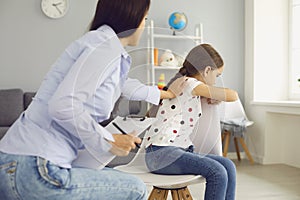 Child psychologist psychology. Woman psychologist with a clipboard helps a child with a problem in the room.