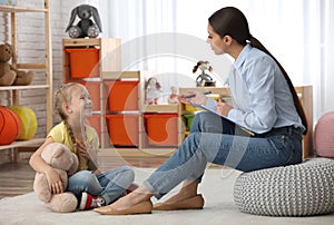 Child psychotherapist working with little girl photo