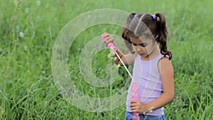 Child puff soap bubbles. girl inflate soap bubbles. little curly girl blowing soap bubbles