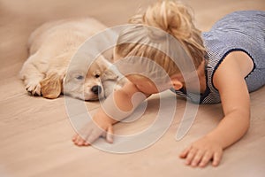Child, puppy and hug with rest, floor and pet with love at house. Kid, dog and golden retriever or sleepy labrador with