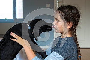 Child and puppy kiss. Dog man`s best friend