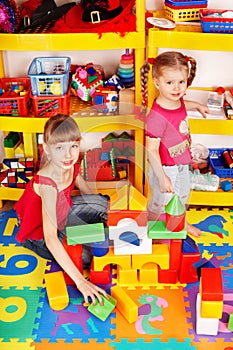 Child with puzzle, block in play room.