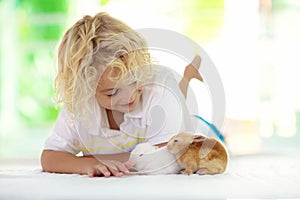 Child with rabbit. Easter bunny. Kids and pets