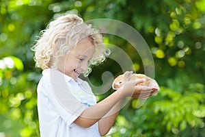 Child with rabbit. Easter bunny. Kids and pets