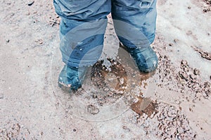 Child rain boots outdoors in action.