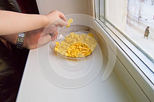 The child reached for the cereal, a little boy and a grown man standing at the window