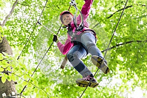 Child reaching platform climbing in high rope course