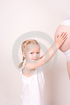 Child reaching pregnant belly