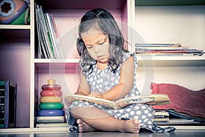 Child read, cute little girl reading a book and sitting on floor