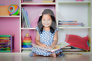 Child read, cute little girl is smiling and reading a book