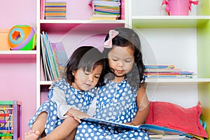 Child read, two cute little girls reading book together