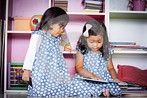 Child read, two cute little girls reading book together