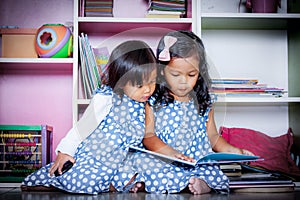 Child read, two cute little girls reading book together on books