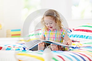 Child reading in bed. Kids read. Girl at home