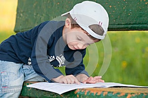 Child reading on a bench