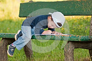 Child reading on a bench