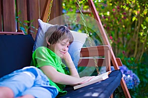 Child reading a book in the garden