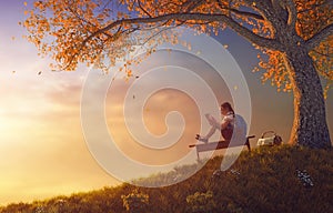 Child reading the book near tree