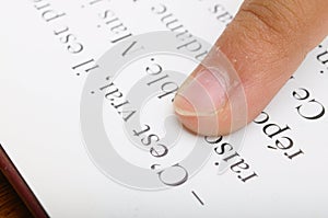 Child reading with his finger on dictionary