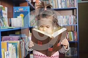 Child reading magic book. little girl in laibrary looking into fairy tale. wonder of education