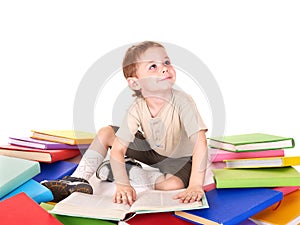 Child reading pile of books.
