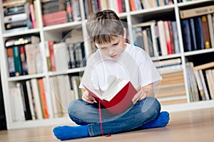 Child reading a red book in the library