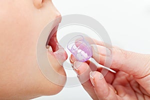 Child receiving homeopathic medication granules photo