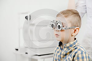 Child reception doctor ophthalmologist selects glasses of lens, check eye sight.