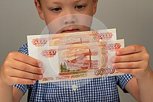 The child recieved money from the state and holds them in his hands