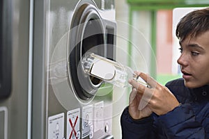 Child recycling plastic bottles in a machine