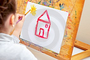 Child is red drawing house photo