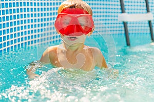Child with Red Goggles Enjoying Swimming Pool Fun