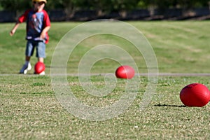 Child with red rugby balls