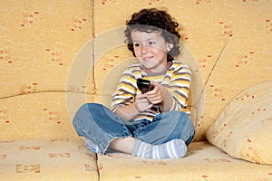 Child with the remote control of television